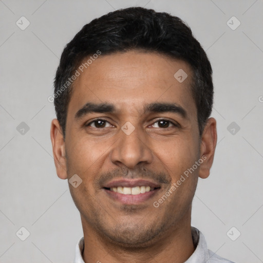 Joyful latino young-adult male with short  black hair and brown eyes