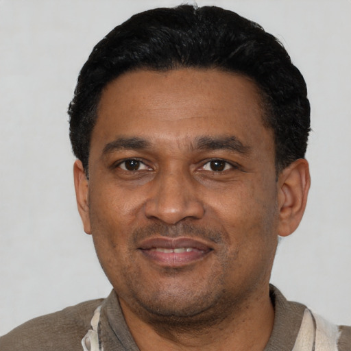 Joyful latino adult male with short  black hair and brown eyes