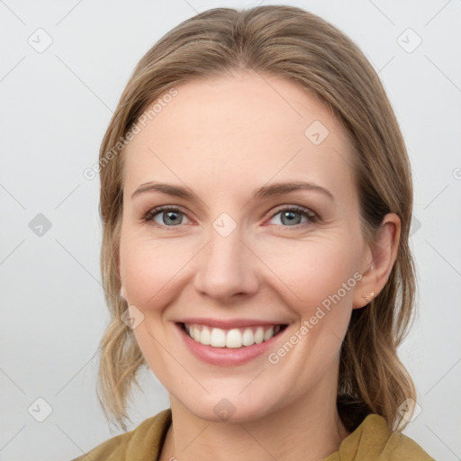 Joyful white young-adult female with medium  brown hair and blue eyes