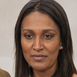 Joyful latino adult female with long  brown hair and brown eyes