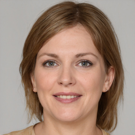 Joyful white adult female with medium  brown hair and grey eyes