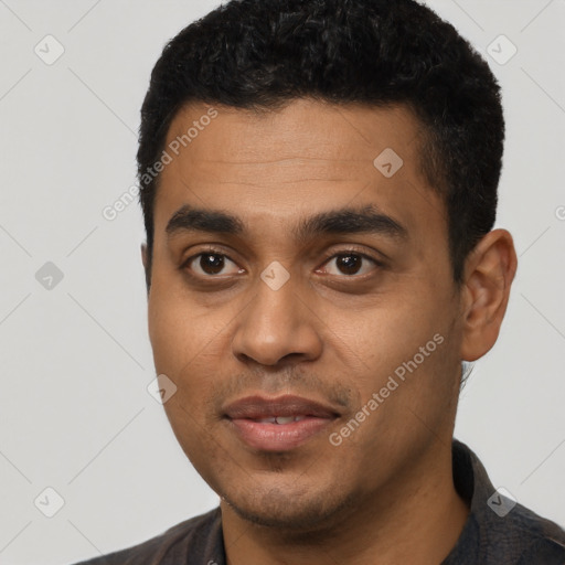 Joyful black young-adult male with short  black hair and brown eyes