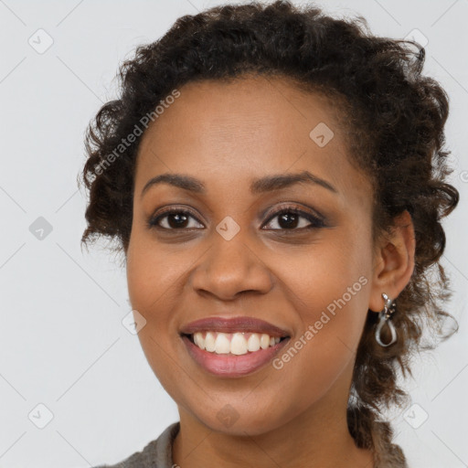 Joyful black young-adult female with long  brown hair and brown eyes