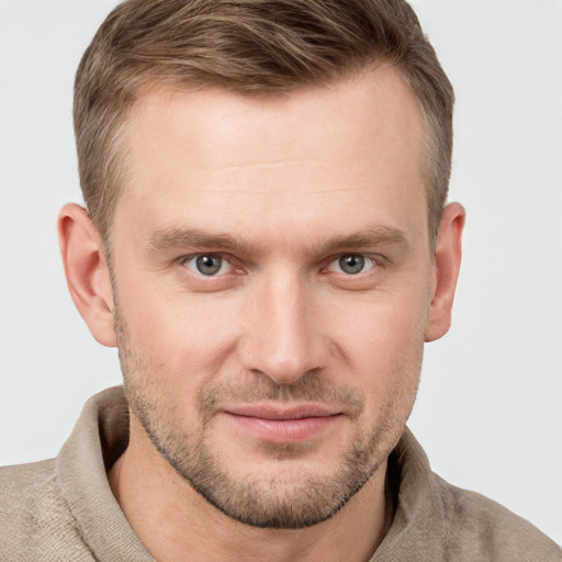 Joyful white young-adult male with short  brown hair and grey eyes