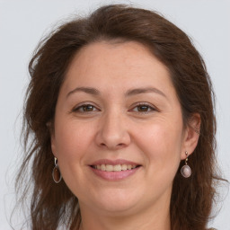 Joyful white adult female with long  brown hair and grey eyes