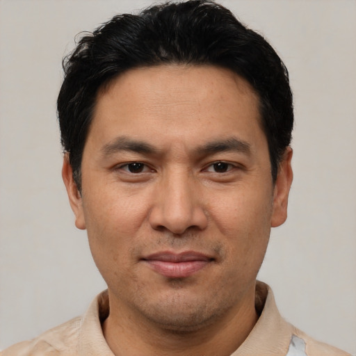 Joyful asian adult male with short  black hair and brown eyes