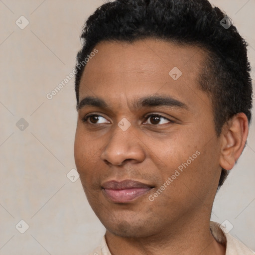 Joyful black young-adult male with short  black hair and brown eyes