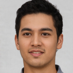 Joyful latino young-adult male with short  brown hair and brown eyes