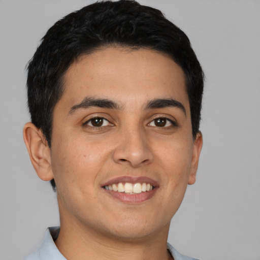 Joyful latino young-adult male with short  black hair and brown eyes