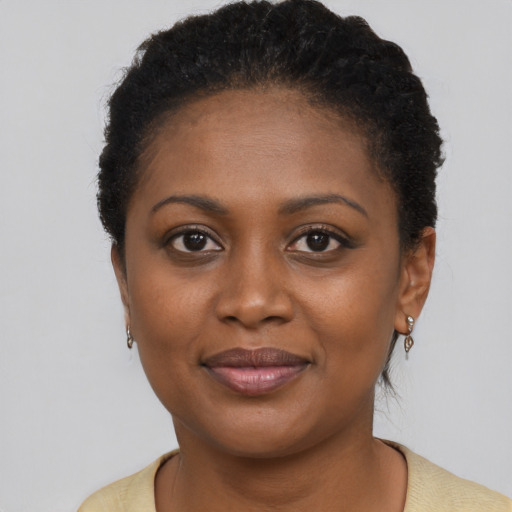 Joyful black young-adult female with short  brown hair and brown eyes