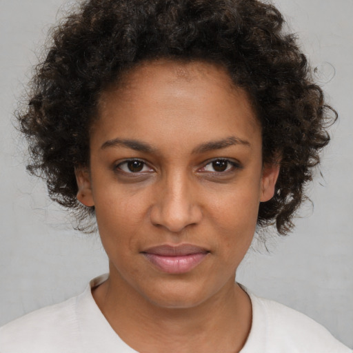Joyful black young-adult female with short  brown hair and brown eyes
