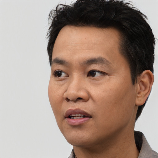 Joyful asian adult male with short  black hair and brown eyes