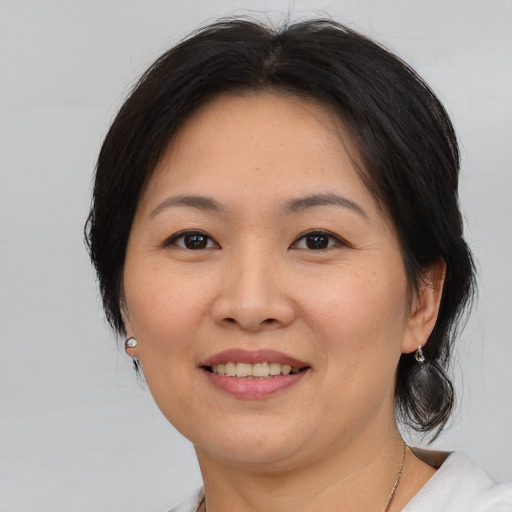 Joyful asian adult female with medium  brown hair and brown eyes