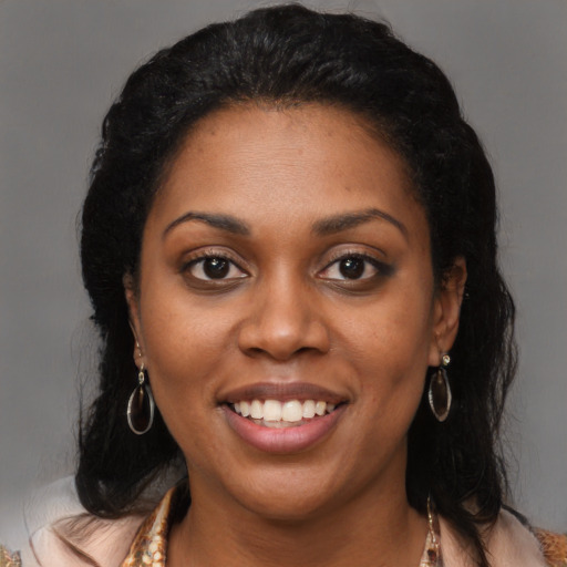 Joyful black young-adult female with long  brown hair and brown eyes