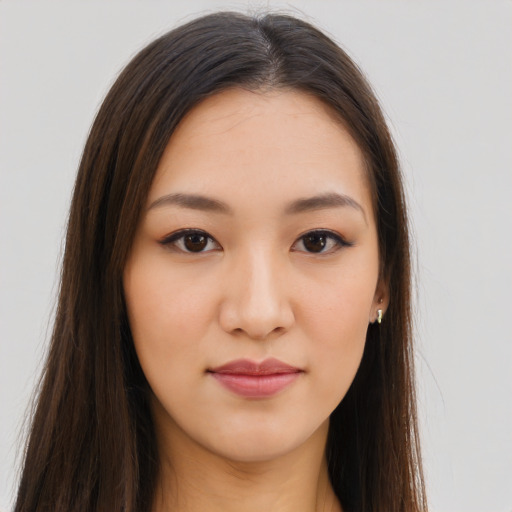 Joyful asian young-adult female with long  brown hair and brown eyes
