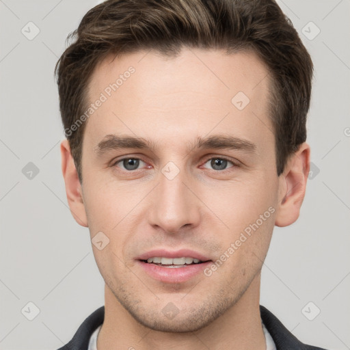 Joyful white young-adult male with short  brown hair and grey eyes