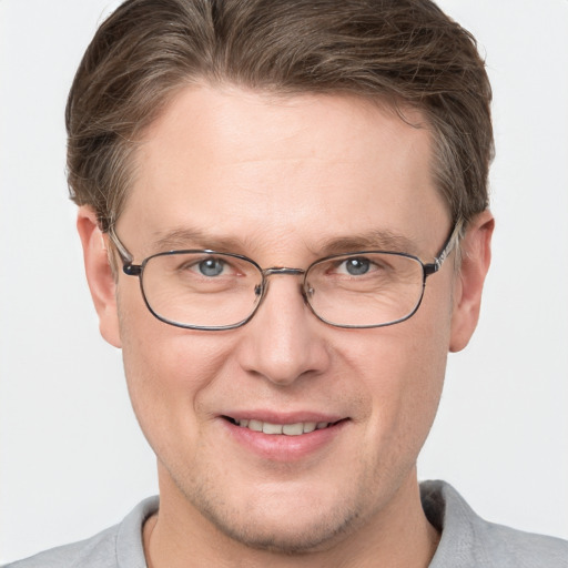 Joyful white adult male with short  brown hair and grey eyes