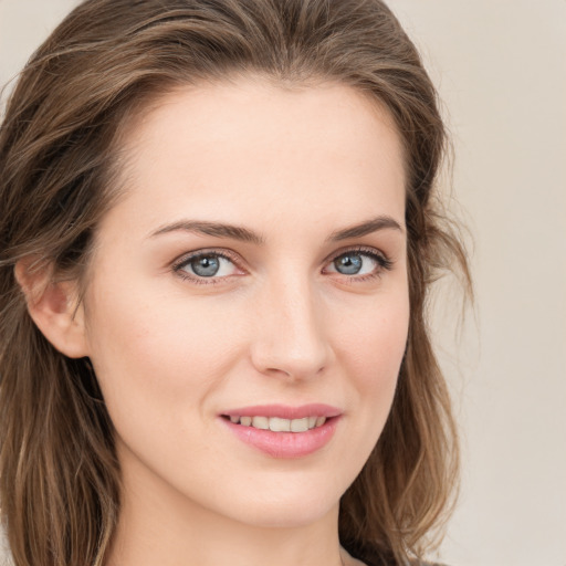 Joyful white young-adult female with long  brown hair and blue eyes