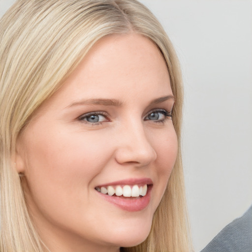 Joyful white young-adult female with long  blond hair and brown eyes