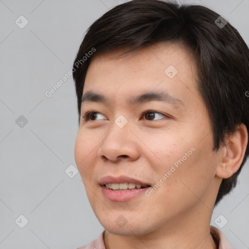 Joyful asian young-adult male with short  brown hair and brown eyes