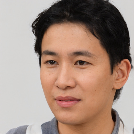 Joyful asian young-adult male with short  black hair and brown eyes