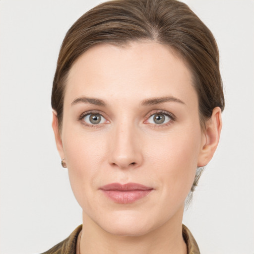 Joyful white young-adult female with medium  brown hair and grey eyes