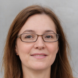 Joyful white adult female with long  brown hair and brown eyes