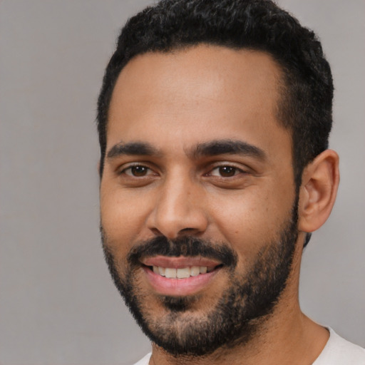 Joyful latino young-adult male with short  black hair and brown eyes