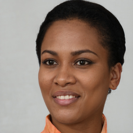 Joyful black young-adult female with short  black hair and brown eyes