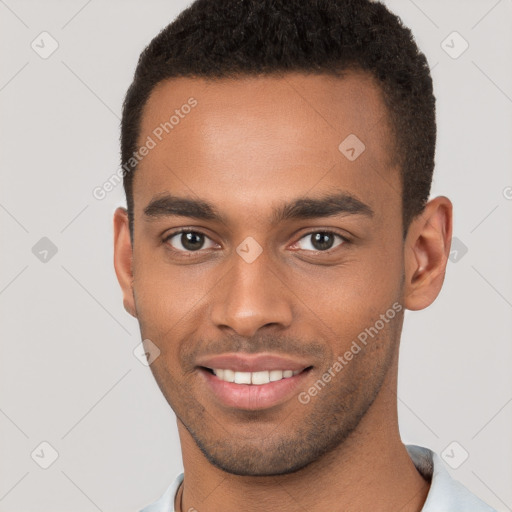 Joyful black young-adult male with short  brown hair and brown eyes