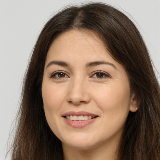 Joyful white young-adult female with long  brown hair and brown eyes