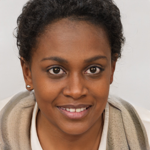 Joyful black young-adult female with short  brown hair and brown eyes