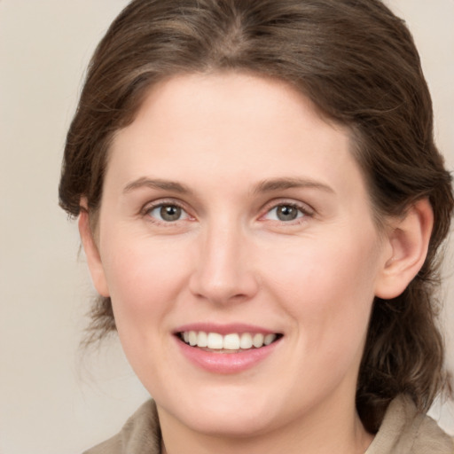 Joyful white young-adult female with medium  brown hair and grey eyes