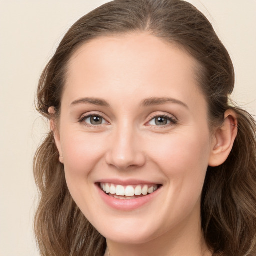 Joyful white young-adult female with long  brown hair and grey eyes