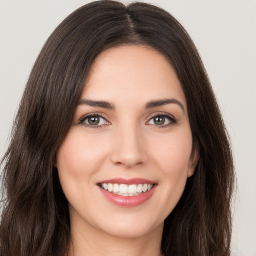 Joyful white young-adult female with long  brown hair and brown eyes