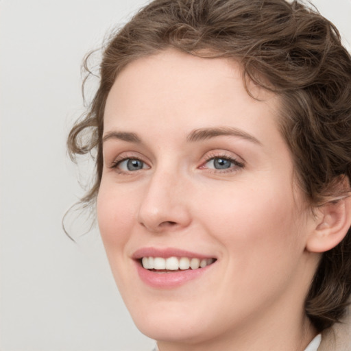 Joyful white young-adult female with medium  brown hair and green eyes