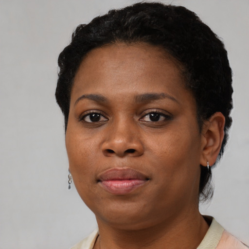 Joyful black young-adult female with short  black hair and brown eyes