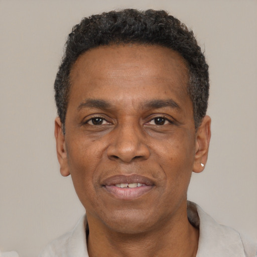 Joyful black adult male with short  black hair and brown eyes