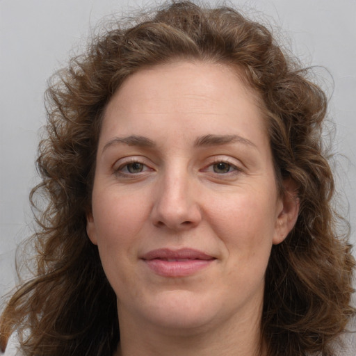 Joyful white adult female with long  brown hair and brown eyes