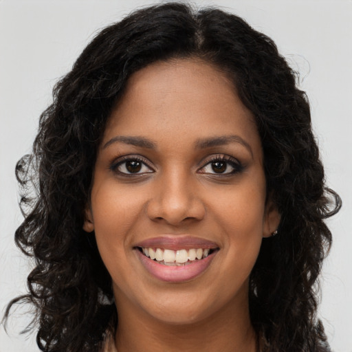 Joyful black young-adult female with long  brown hair and brown eyes