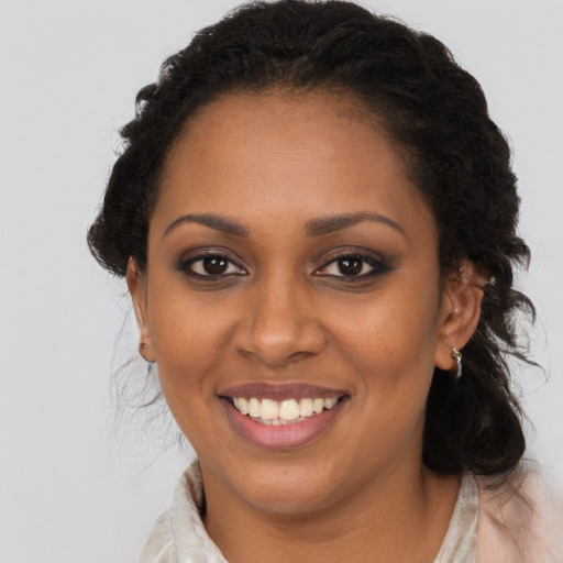 Joyful black young-adult female with long  brown hair and brown eyes