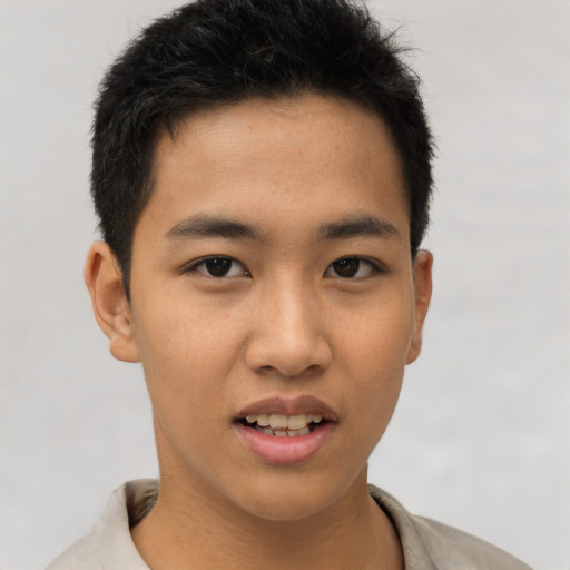 Joyful asian young-adult male with short  brown hair and brown eyes