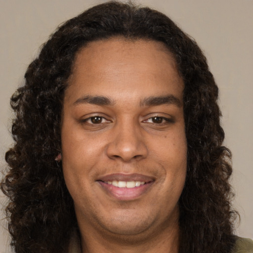 Joyful black young-adult male with long  brown hair and brown eyes