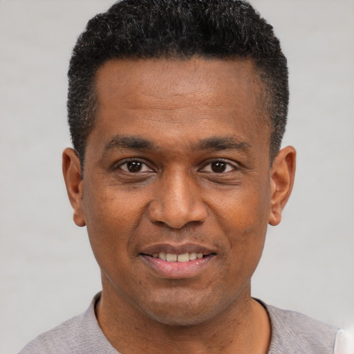 Joyful black young-adult male with short  black hair and brown eyes