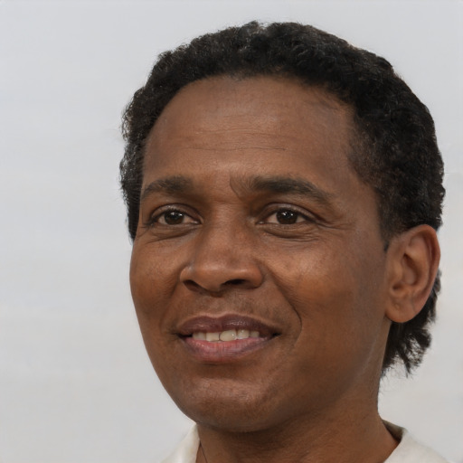 Joyful black adult male with short  brown hair and brown eyes