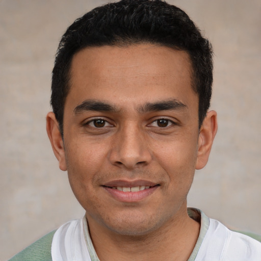 Joyful white young-adult male with short  black hair and brown eyes