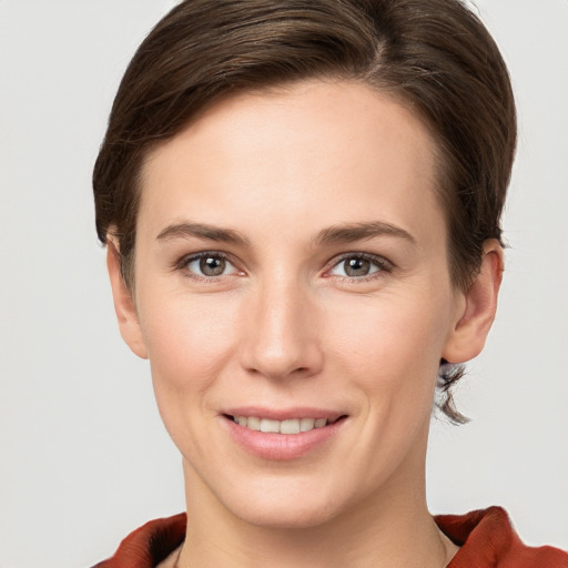 Joyful white young-adult female with short  brown hair and grey eyes