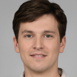 Joyful white young-adult male with short  brown hair and grey eyes