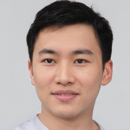 Joyful asian young-adult male with short  black hair and brown eyes