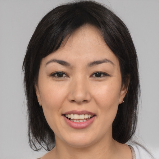 Joyful asian young-adult female with medium  brown hair and brown eyes